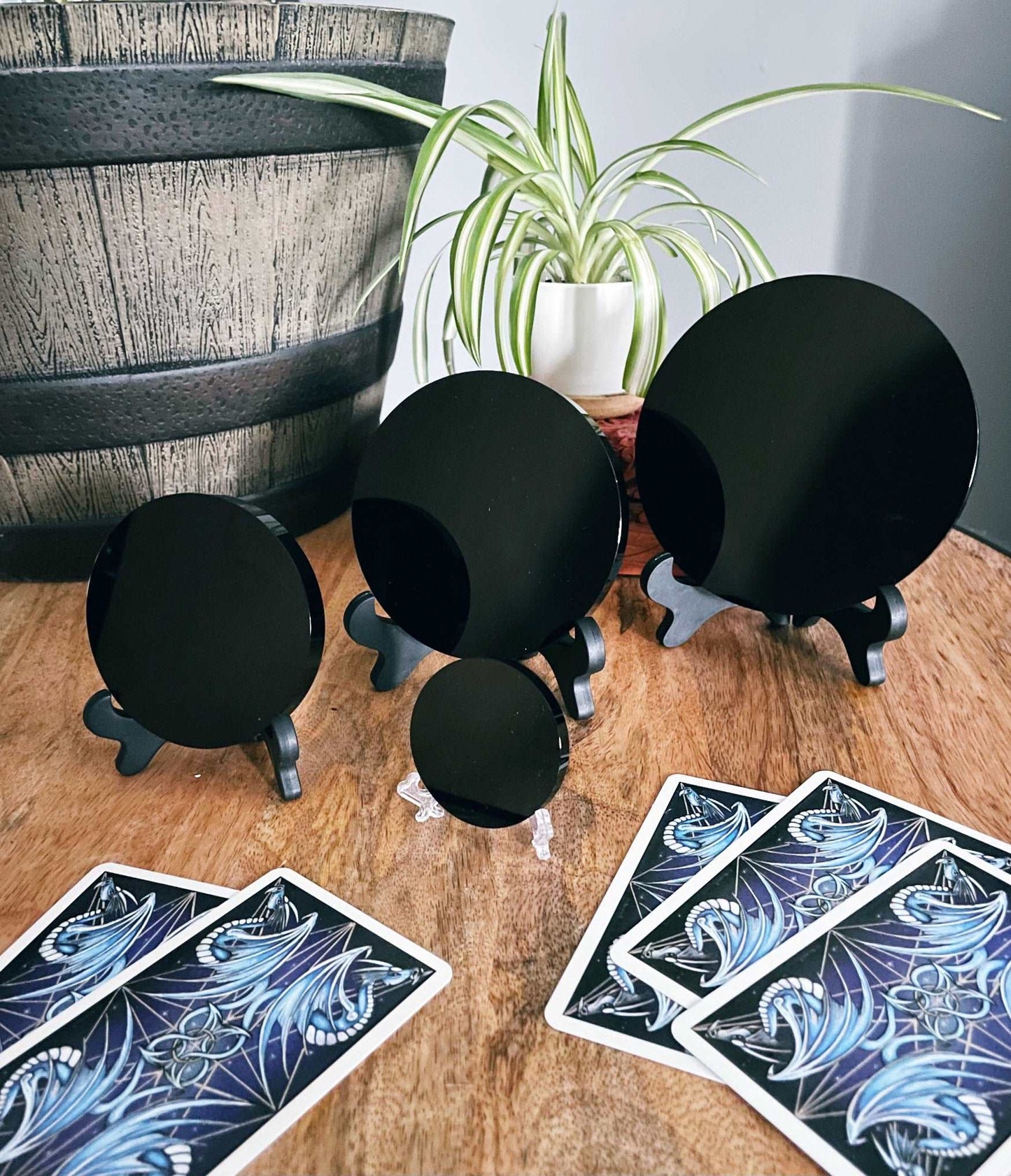 Pictured is a scrying mirror on a stand. The scrying mirror is carved out of black obsidian. Black Obsidian Scrying Mirror 5cm (with stand) front comparison