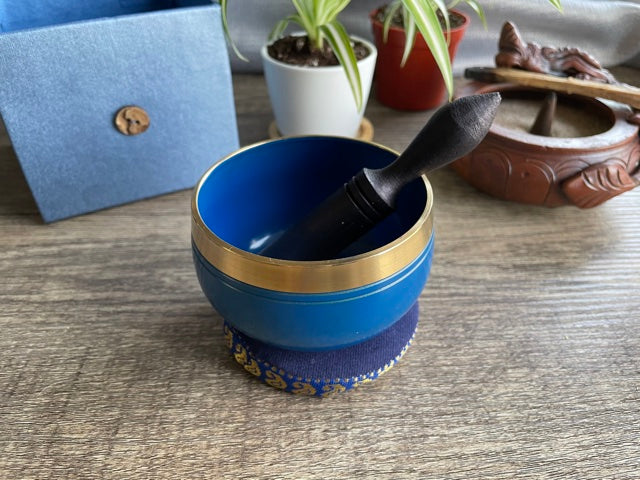 Pictured is a small metal singing bowl with a pillow and a wood gong mallet. Indigo Singing Bowl (Third Eye Chakra)