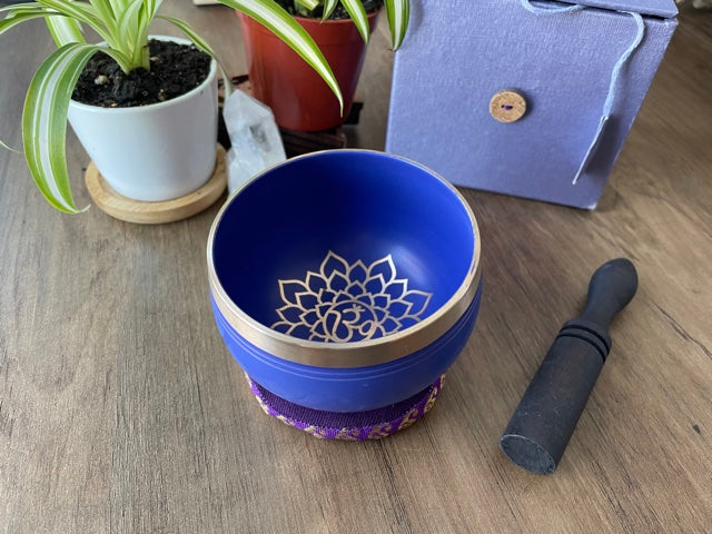Pictured is a small metal singing bowl with a pillow and a wood gong mallet. Purple Singing Bowl (Crown Chakra) 8cm