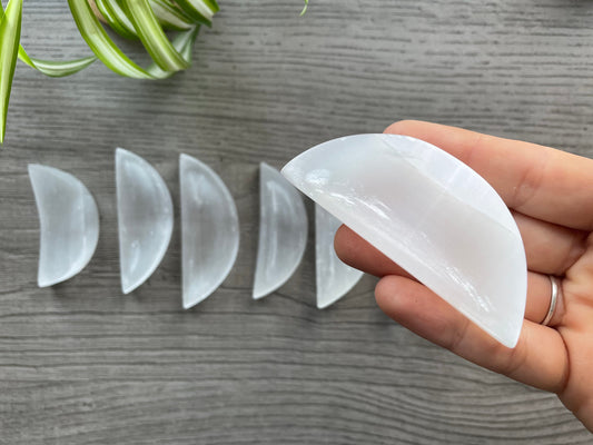 Pictured is a crescent-shaped bowl carved out of selenite. Mini Selenite (Satin Spar) Crystal Moon Bowls close up