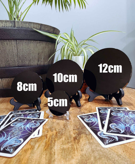 Pictured is a scrying mirror on a stand. The scrying mirror is carved out of black obsidian. Black Obsidian Scrying Mirror 5cm (with stand) size comparison