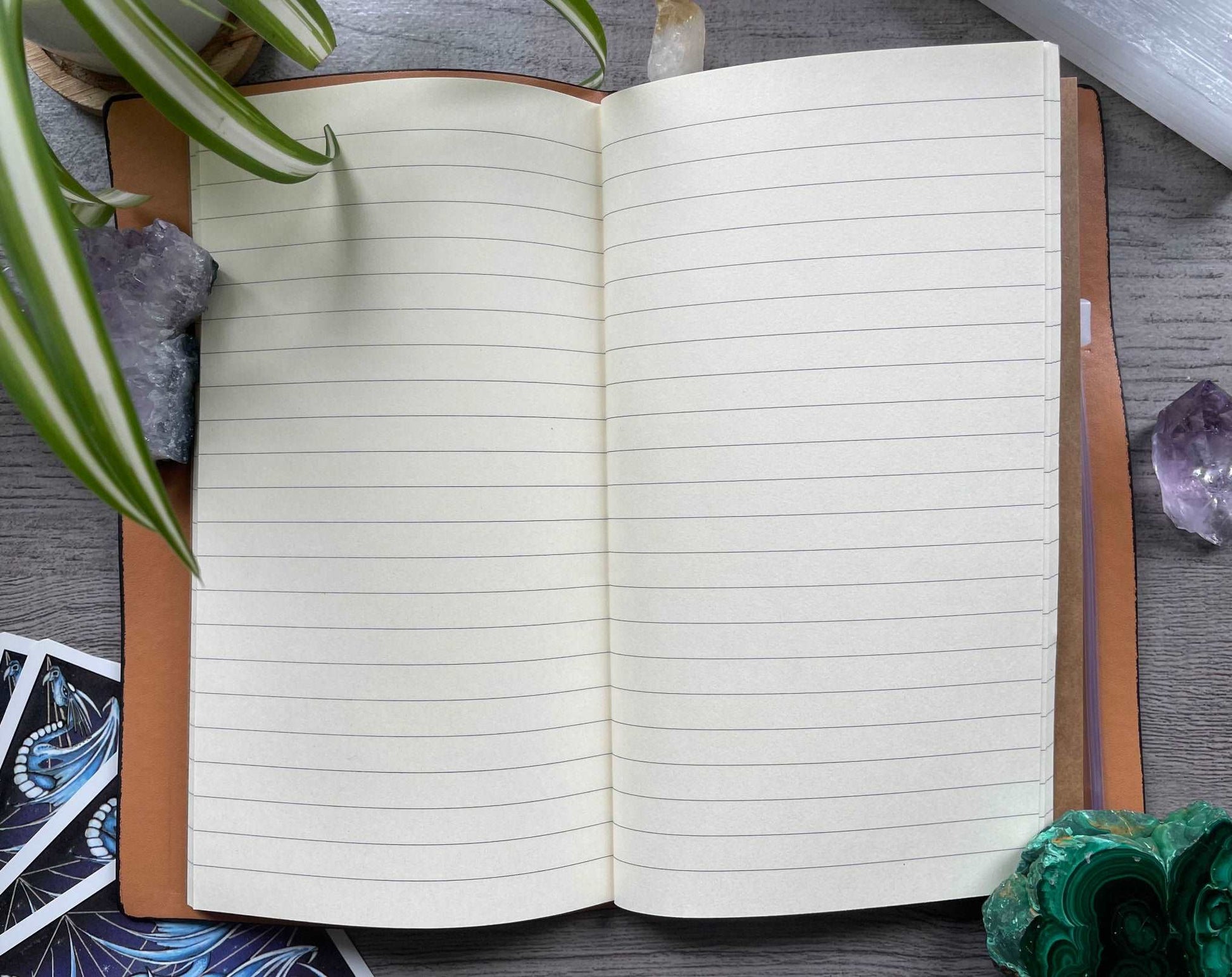 Pictured is a faux leather refillable notebook with a crystal. Faux Leather Spiritual Symbols Refillable Notebook (Black) inside