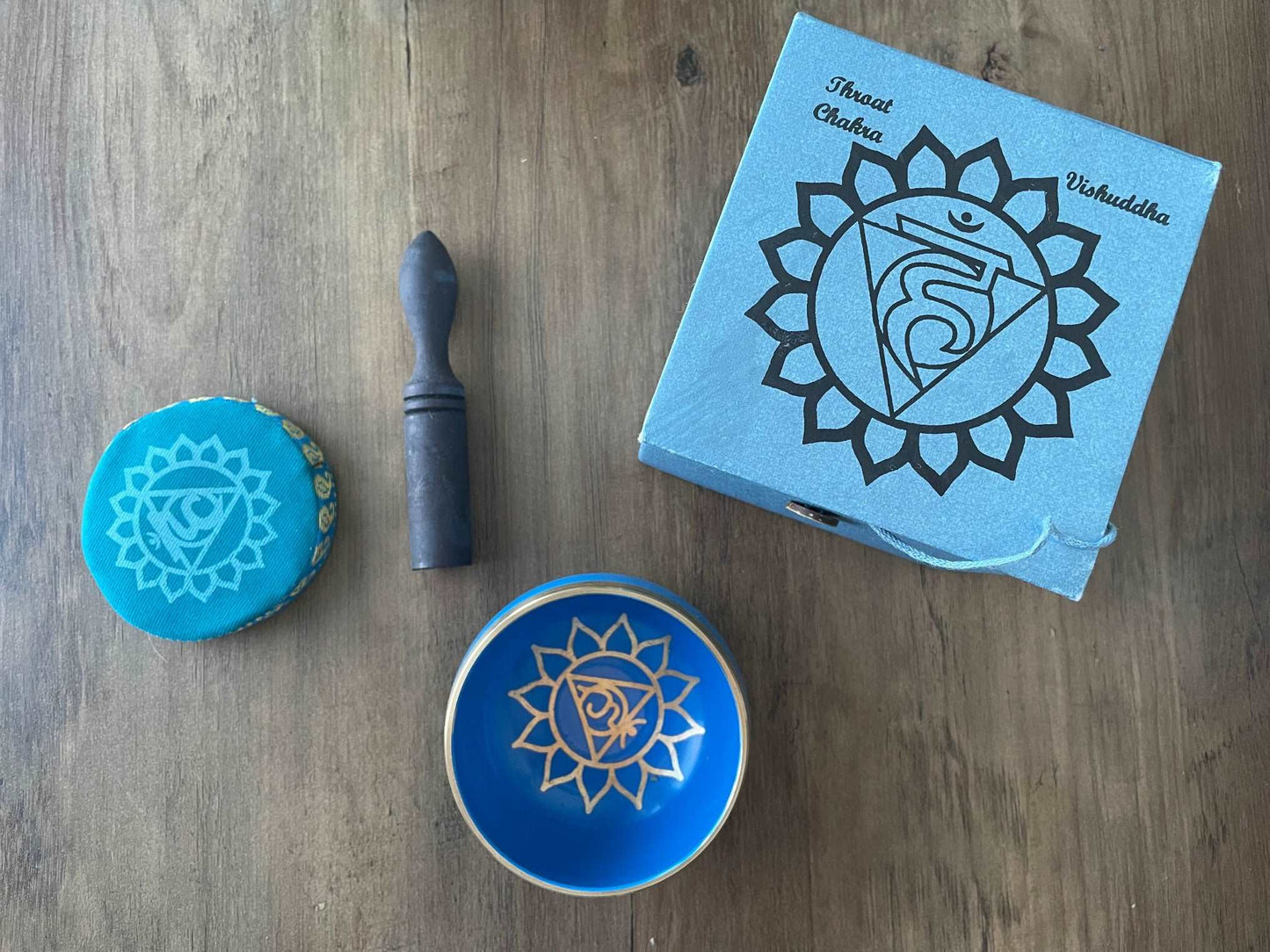 Pictured is a small metal singing bowl with a pillow and a wood gong mallet. Blue Singing Bowl (Throat Chakra) 8cm top