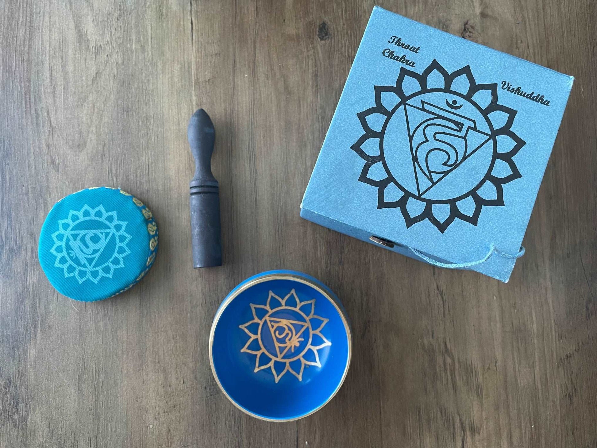 Pictured is a small metal singing bowl with a pillow and a wood gong mallet. Blue Singing Bowl (Throat Chakra) 8cm top