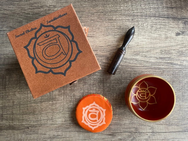 Pictured is a small metal singing bowl with a pillow and a wood gong mallet. Orange Singing Bowl (Sacral Chakra) top