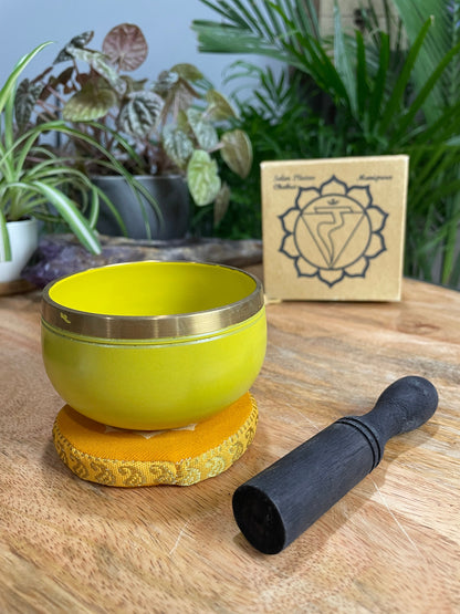 Pictured is a small metal singing bowl with a pillow and a wood gong mallet. Yellow Singing Bowl (Solar Plexus Chakra) 8cm