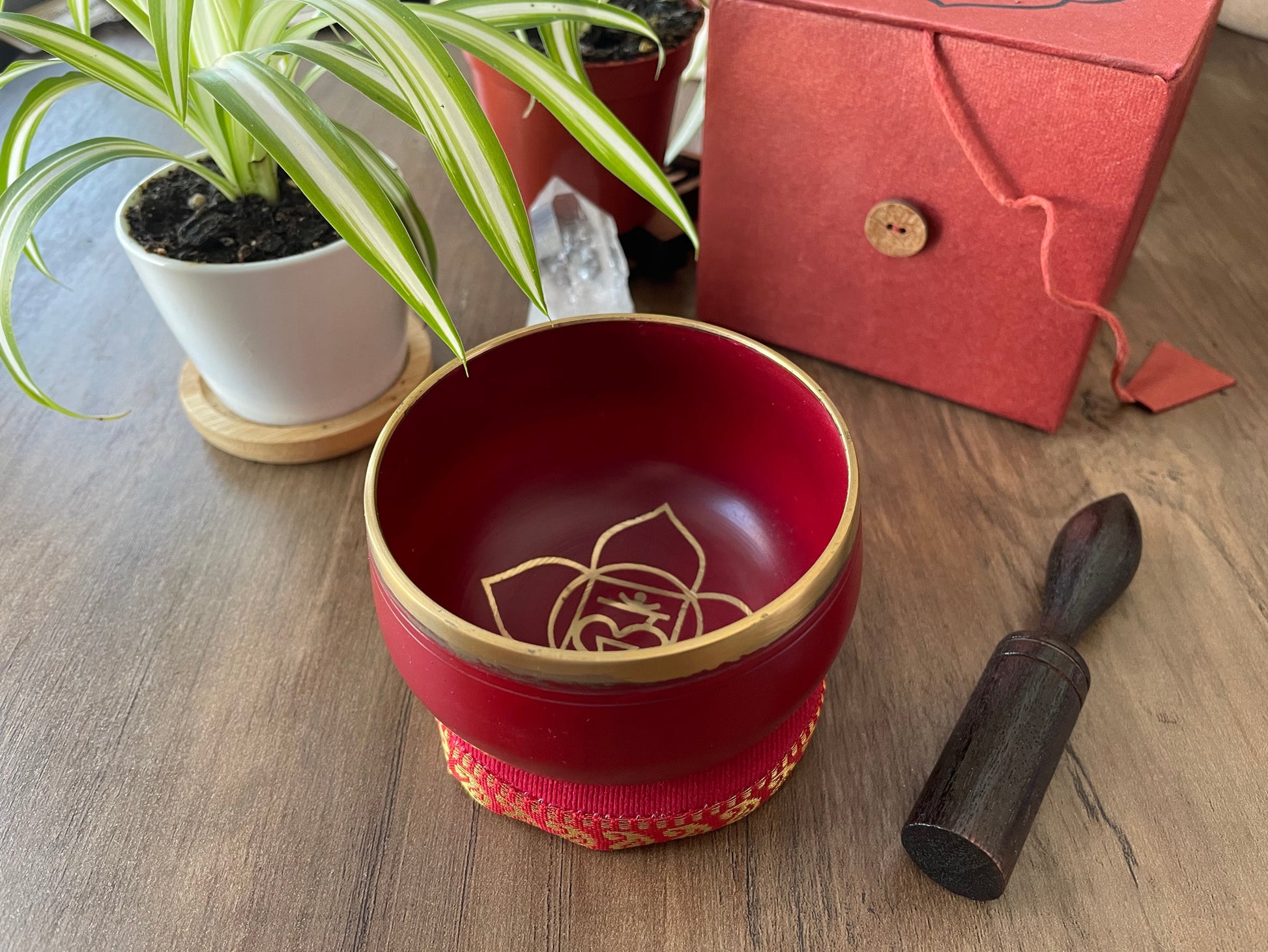 Pictured is a small metal singing bowl with a pillow and a wood gong mallet. Red Singing Bowl (Root Chakra) 8cm
