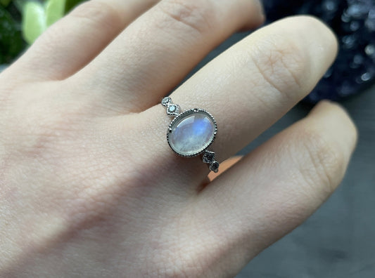Pictured is a white moonstone gemstone set in an S925 sterling silver ring. White Moonstone S925 Sterling Silver Ring (Style 2 - A) - The Wandering Fox Emporium, Your Crystal Store close up